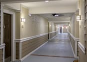 Thumbnail 76 of 80 - A long hallway with a light on the wall and a fan on the ceiling.
