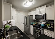 Thumbnail 8 of 80 - A modern kitchen with a stainless steel refrigerator, oven, and microwave.