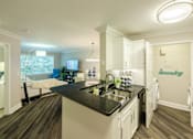 Thumbnail 11 of 80 - A kitchen with a black counter top and white cabinets.