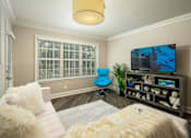 Thumbnail 13 of 80 - A living room with a blue chair and a television.