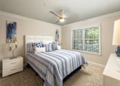 Thumbnail 14 of 80 - A bedroom with a bed, nightstands, and a ceiling fan.