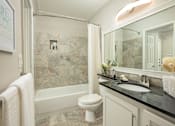 Thumbnail 77 of 80 - A bathroom with a toilet, sink, and a bathtub.