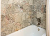 Thumbnail 78 of 80 - A bathroom with a marble wallpaper and a white bathtub.
