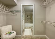 Thumbnail 79 of 80 - A white chair with a fluffy seat sits in a hallway with a white doorway leading to a bathroom.