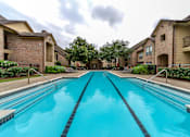 Thumbnail 9 of 14 - A swimming pool in front of apartment buildings.