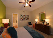 Thumbnail 14 of 14 - A bedroom with a bed, a chair, a dresser, and a ceiling fan.