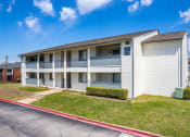 Thumbnail 15 of 16 - a white apartment building with balconies and a sidewalk at The Hudson, Carrollton Texas?