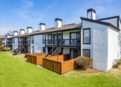 Thumbnail 18 of 20 - a row of apartment buildings with wooden decking at Keller Oaks, Carrollton, TX 75006 ?