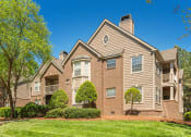 Thumbnail 23 of 23 - a brick apartment building with trees and grass at Radbourne Lake Apartments, Charlotte, 28269 ?