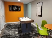 Thumbnail 10 of 32 - a game room with a table and chairs and a dart board