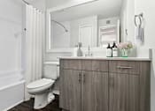 Thumbnail 23 of 29 - A white toilet sits in a bathroom next to a wooden cabinet.