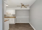 Thumbnail 18 of 32 - an empty kitchen with white cabinets and a ceiling fan at The Grove Brentwood, Nashville, TN ?