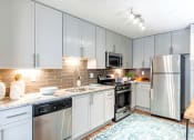 Thumbnail 1 of 30 - a kitchen with stainless steel appliances and white cabinets