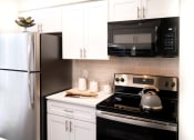Thumbnail 5 of 20 - a kitchen with white cabinets and black appliances and a refrigerator at Keller Oaks, Carrollton Texas?