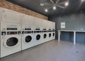 Thumbnail 14 of 32 - a laundry room with washers and dryers and a table