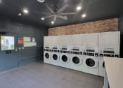 Thumbnail 16 of 32 - a laundry room with a bunch of washers and dryers