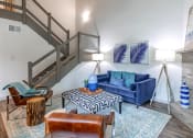 Thumbnail 4 of 30 - a living room with a blue couch and a staircase