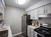 Thumbnail 10 of 32 - A kitchen with a stove, refrigerator, and cabinets. at The Grove Brentwood, Nashville, TN 37211 