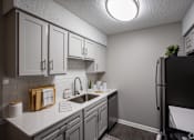 Thumbnail 9 of 32 - A kitchen with a black refrigerator and white cabinets. at The Grove Brentwood, Nashville, TN 37211 