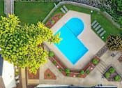 Thumbnail 2 of 35 - A swimming pool surrounded by a brick wall and trees.