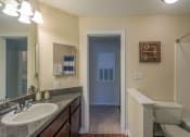 Thumbnail 11 of 23 - a bathroom with a large mirror and a sink and a toilet at Radbourne Lake Apartments, Charlotte ?