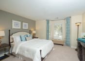 Thumbnail 17 of 23 - a bedroom with a bed and a dresser and a window at Radbourne Lake Apartments, Charlotte North Carolina?