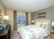Thumbnail 19 of 23 - a bedroom with a bed and a dresser and a window at Radbourne Lake Apartments, North Carolina ?