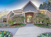 Thumbnail 6 of 23 - the front of the clubhouse with a walkway and two trees at Radbourne Lake Apartments, North Carolina, 28269