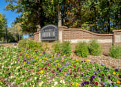 Thumbnail 7 of 23 - a sign in front of a brick wall with flowers at Radbourne Lake Apartments, Charlotte, NC 28269 ?