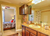 Thumbnail 8 of 20 - a bathroom with a sink and a toilet and a mirror at Stone Creek at Old Farm Apartments, Houston