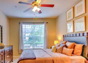 Thumbnail 17 of 20 - a bedroom with a large bed and a ceiling fan at Stone Creek at Old Farm Apartments, Houston, TX 77063