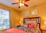 Thumbnail 12 of 20 - a bedroom with a large window and a ceiling fan at Stone Creek at Old Farm Apartments, Houston, TX