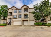 Thumbnail 4 of 20 - front view of an apartment building with garages and trees at Stone Creek at Old Farm Apartments, Houston