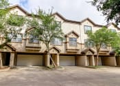 Thumbnail 7 of 20 - the front of a house with two garages and trees at Stone Creek at Old Farm Apartments, Houston, Texas