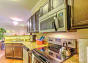 Thumbnail 11 of 20 - a kitchen with stainless steel appliances and a microwave at Stone Creek at Old Farm Apartments, Houston, TX 77063