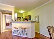 Thumbnail 15 of 20 - a living room with a bar with three stools at Stone Creek at Old Farm Apartments, Texas