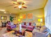 Thumbnail 18 of 20 - a living room with furniture and a ceiling fan at Stone Creek at Old Farm Apartments, Houston, TX