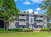 Thumbnail 7 of 27 - a blue and white apartment building with trees in front of it