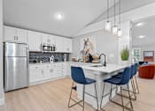 Thumbnail 10 of 27 - a kitchen with white cabinetry and a large white island with three blue chairs