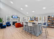 Thumbnail 11 of 27 - a living room with a fireplace and a bar with stools