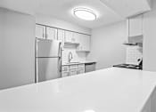 Thumbnail 14 of 27 - a kitchen with a white counter top and a stainless steel refrigerator