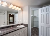 Thumbnail 5 of 14 - A bathroom with a sink, mirror, and lighting fixture.