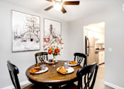 Thumbnail 3 of 58 - A dining room with a table set for two and a framed picture on the wall.