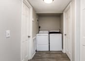 Thumbnail 7 of 58 - A small laundry room with a washer and dryer.