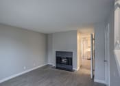 Thumbnail 28 of 32 - an empty living room with a fireplace and a hallway with a door