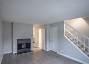 Thumbnail 27 of 32 - an empty living room with a fireplace and stairs