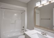 Thumbnail 32 of 32 - a bathroom with a shower and a sink and a mirror