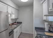 Thumbnail 17 of 32 - a kitchen with stainless steel appliances and white cabinets
