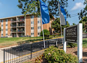 Thumbnail 2 of 18 - A sign for Woods at Addison stands in front of a building.