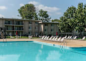 Thumbnail 18 of 18 - A swimming pool in front of a building with lounge chairs around it.